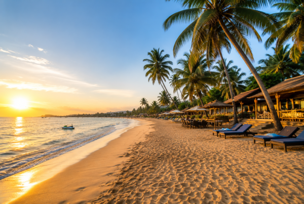 Candolim Beach in Goa with golden sunset, palm trees, beachside resorts and calm Arabian Sea waves.